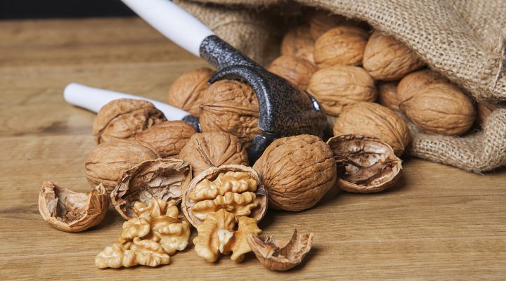 Whole unpeeled and broken walnuts on a white background. Still life rustic photo.